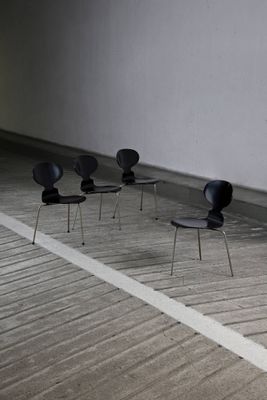 four black chairs sitting in a row in a room