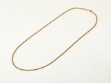 a gold necklace with a chain on a white background