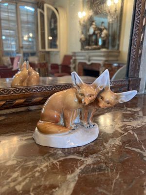 une figurine représentant deux renards assis sur une table