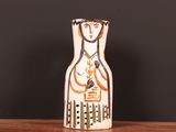 un petit vase décoré d'une peinture, posé sur une table