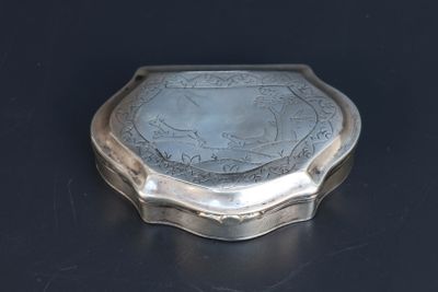 une boîte argentée ornée d'un motif sur un fond noir