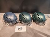 three helmets are lined up on a table with a price tag