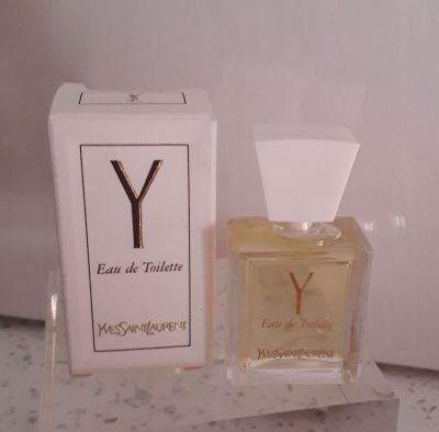 un flacon de parfum posé sur un comptoir à côté d'une boîte