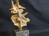 a bronze sculpture of a tree on a marble base