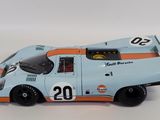 an old model of a blue and orange race car on a white surface