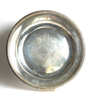 a silver plate on a white surface with a shadow on it