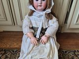 an antique doll sitting on a rug in a living room