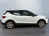 the white car is parked in a large room with a gray floor