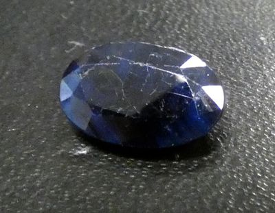 a close up of a blue sapphire stone on a black surface