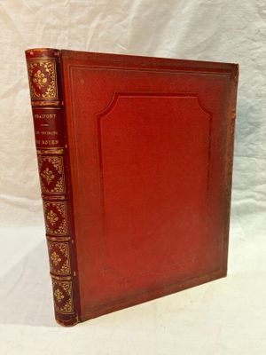 an old red book sitting on top of a white table