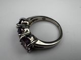 a close up of a ring with a purple stone in it