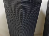 pair of black wicker planters on a white background