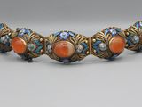 un bracelet en or orné de corail et de perles de verre bleues