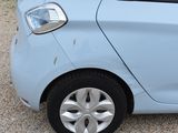 a small blue car that is parked on the side of the road