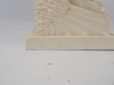 a white sculpture of a bird on a stand