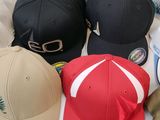 several different colored hats are lined up on a white surface