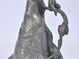 une statue de femme tenant une fleur à la main