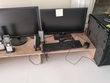 deux écrans d'ordinateur et un clavier posés sur un bureau en bois