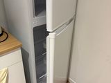 un réfrigérateur blanc dans le coin d'une cuisine