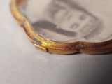 a close up of a gold bracelet with a picture on it