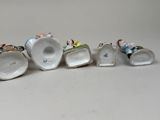 six porcelain figurines of people sitting on top of each other