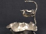 une assiette en argent antique avec un oiseau sur le dessus
