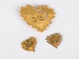 three pieces of gold are shown on a white surface
