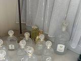 bottles of perfume are lined up on a counter in a bathroom