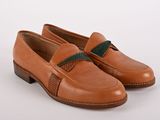 une paire de chaussures marron avec un ruban vert sur le côté