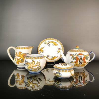 une image représentant un ensemble de théières et de soucoupes posées sur une table