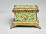a small green box with a floral design on it