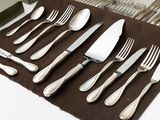 a set of silverware on a brown place mat