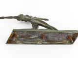 bronze sculpture of a woman on a surfboard on a white surface