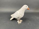 un petit oiseau blanc posé sur une table