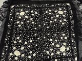 une vieille photo en noir et blanc représentant un morceau de tissu orné de fleurs