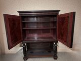 a wooden cabinet with a door open in the corner of a room