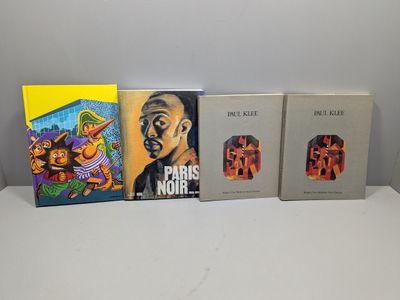 Trois livres sont alignés sur une table blanche
