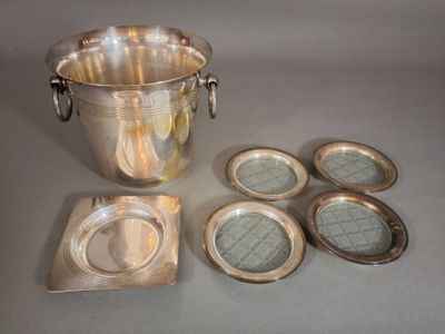 un seau à glace en argent et six dessous de verre en argent posés sur une table