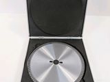 a metal case with a disc in it on a white surface
