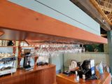 a bar with a bunch of wine glasses hanging from the ceiling