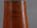 a brown vase that has a wooden handle on it