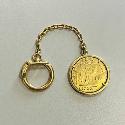 un gros plan d'un porte-clés sur lequel est posée une pièce de monnaie