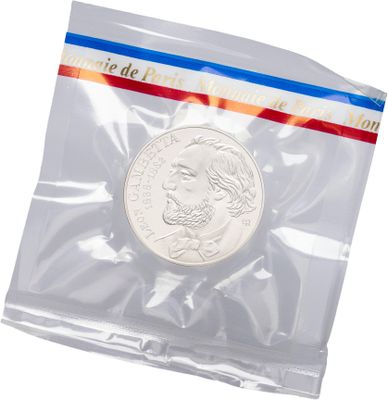 a close up of a coin in a plastic bag on a white background