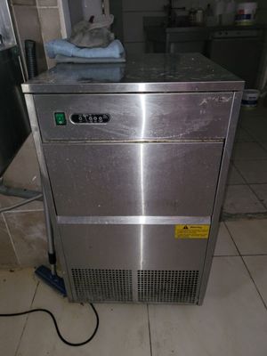a stainless steel machine that is sitting on a tiled floor