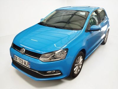 La Volkswagen Polo bleue est garée dans une pièce blanche.