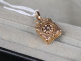 a small gold pendant with a flower on it