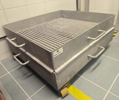 an image of a stainless steel grill on a tiled floor