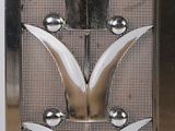 a close up of a metal door with a flower design on it