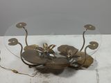 a glass table with a metal flower on top of it