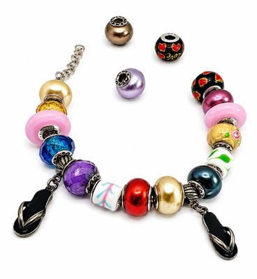 un bracelet composé de perles de différentes couleurs sur fond blanc